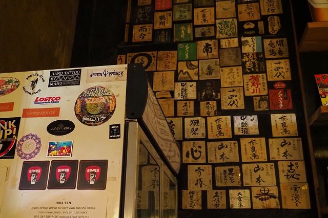 sakanaの壁の貼られた日本酒ラベルとantarisのステッカー